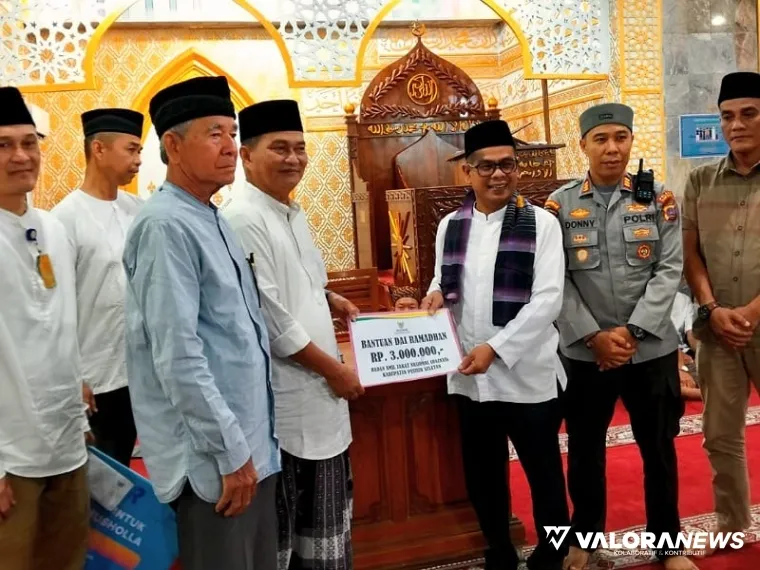 Wakil Bupati Risnaldi, memberikan bantuan Baznas kepada Marwan Anas, pengurus Masjid Raya Nurul Ulum Barung Barung Balantai, Kecamatan Koto XI Tarusan, Jumat (21/3/2025). FOTO: tusrisep