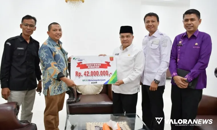 Bupati Agam, Benni Warlis serahkan santunan kematian dari BPJS Ketenagakerjaan Cabang Bukittinggi sebesar Rp42 juta untuk petugas adhoc Pilkada Kabupaten Agam 2024 ke anggota KPU Agam, Zainal Abadi, Rabu. (humas)