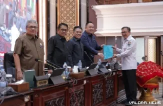 Pj Sekdaprov Sumbar, Yozawardi menyerahkan nota jawaban gubernur terhadap pandangan umum anggota DPRD Sumbar terhadap Ranperda SPBE ke pimpinan rapat, Nanda Satria pada rapat paripurna, Jumat. (humas)