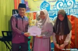 Wakil Ketua DPRD Sumbar, Evi Yandri menyerahkan hadiah pada pemenang MTQ tingkat Kota Padang yang digelar pemuda dan remaja Masjid Quba, Kelurahan Lambuang Bukik, Sabtu malam. (humas)