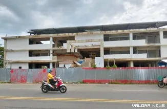 Seorang pengendara motor melintas di depan bangunan Pasar Painan di Kecamatan IV Jurai, Kabupaten Pesisir Selatan, yang terbengkalai pengerjaan pembangunannya, Sabtu (22/3/2025). FOTO: tusrisep