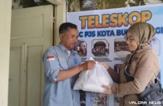 Bendahara DPC PJS Bukittinggi, Alex Armanca, serahkan paket sembako berupa bahan pembuat kue pada salah seorang anggota, jelang Idul Fitri 1446 H di Sekretariat DPC PJS Kota Bukittinggi, Kamis. (hamriadi)