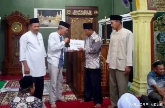 Sekdakab Pessel Mawardi Roska menyerahkan bantuan Rp 15 juta ke Masjid Imaduddin, Simpang Ampang Pulai,  Kecamatan Koto XI Tarusan, Kamis (20/3/2025). FOTO: Dok Balai Jurnalis Kabupaten Pesisir Selatan