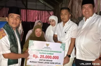 Wagub Sumbar, Vasko Ruseimy serahkan secara simbolis bantuan uang untuk perbaikan rumah bagi Fitri yang terpaksa tinggal di kandang puyuh bersama buah hatinya, Senin. (humas)