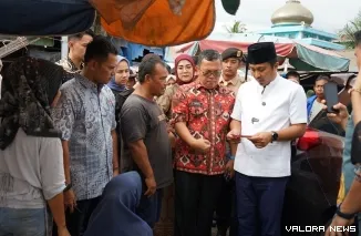 Wagub Sumbar, Vasko Ruseimy memeriksa uang palsu pecahan Rp100 ribu yang diterimanya dari pedagang sayur di Pasar Bandar Buat, Kamis. (humas)