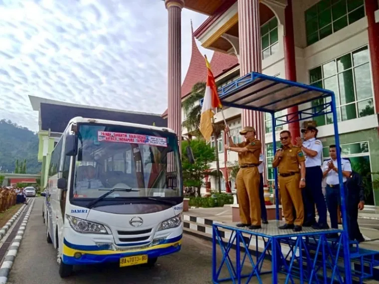 Bupati Pesisir Selatan, Hendrajoni (pegang bendera) meresmikan dimulainya operasional armada bus DAMRI rute Pasar Baru - Tapan di depan Kantor Bupati setempat. FOTO: Dok Diskominfo Pessel