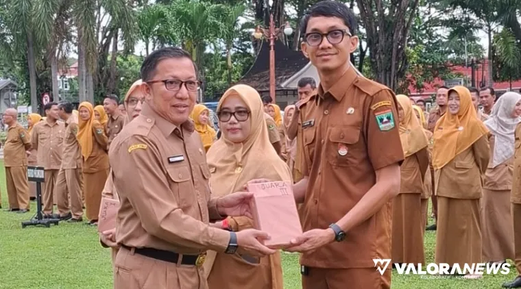 Pj Sekdaprov Sumbar, Yozawardi Usama Putra memberikan penghargaan pada Staf Biro Adpim yang berhasil rumuskan Renstra dan Cascading, usai apel Senin pagi. (humas)