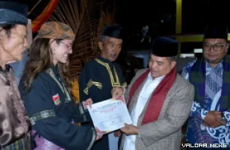 Bupati Agam, Benni Warlis menyerahkan sertifikat pada orang asing yang belajar silat minang saat membuka silaturahmi sasaran silek tradisi se Agam Timur, di Galanggang Surau Ka'bah Inyiak Tuah, Ahad malam. (humas)