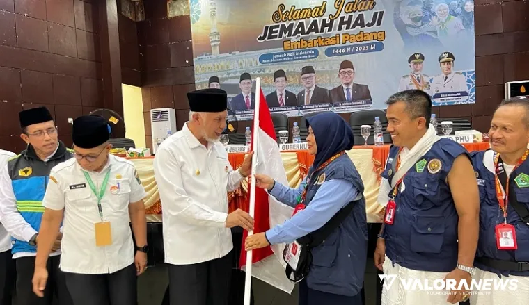 Gubernur Sumbar, Mahyeldi menyerahkan pataka Sumbar pada pembimbing haji Kloter 14 Embarkasi Padang, Rabu. (humas)