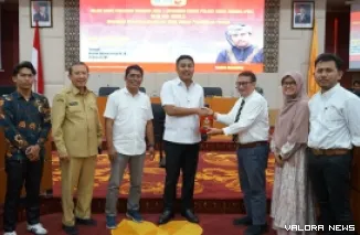 Dekan FIS UNP, Afriva Khaidir serahkan hasil riset tentang implementasi Silek Tradisi Minang jadi ekstrakurikuler wajib di sekolah, pada kuliah umum, Selasa. (humas)