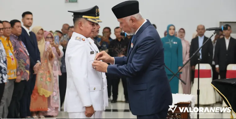 Gubernur Sumbar, Mahyeldi memasangkan benggo kepala daerah pada Welly Suhery dan Parulian sebagai Bupati dan Wakil Bupati Pasaman periode 2025-2030 di auditorium gubernuran, Jumat. (humas)