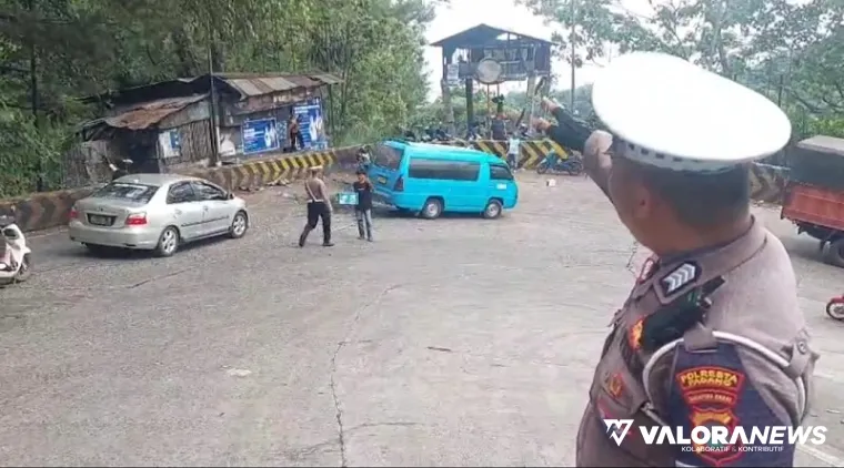 Personel Satlantas Polresta Padang, mengatur arus lalu lintas di tanjakan tajam Sitinjau Lauik, Senin siang. Di lokasi ini sempat terjadi kemacetan parah selang dua hari terakhir. (istimewa)