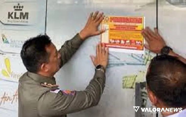 Personel Satpol PP Pekanbaru, memasang pengumuman penyegelan kantor PT Sanel di Jalan Teuku Umar, Kecamatan Limapuluh, Pekanbaru, Rabu siang. (humas)
