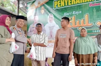 Kapolres Pasaman Barat AKBP Agung Tribawanto menyerahkan daging kurban pada warga sekitar Mapolres, usai penyembelihan, Sabtu. (robbi irwan)