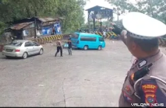 Personel Satlantas Polresta Padang, mengatur arus lalu lintas di tanjakan tajam Sitinjau Lauik, Senin siang. Di lokasi ini sempat terjadi kemacetan parah selang dua hari terakhir. (istimewa)