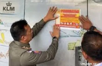 Personel Satpol PP Pekanbaru, memasang pengumuman penyegelan kantor PT Sanel di Jalan Teuku Umar, Kecamatan Limapuluh, Pekanbaru, Rabu siang. (humas)