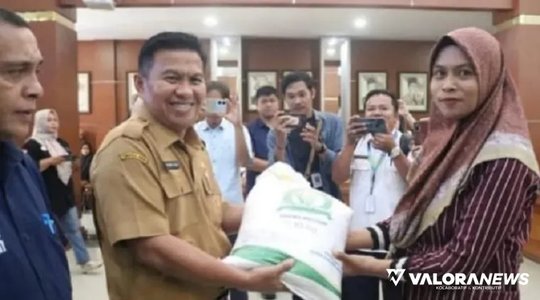Sekda Bukittinggi, Rismal Hadi secara simbolis menyalurkan bantuan beras pada warga yang berhak di Aula Balai Kota Bukittinggi, Selasa. (huam)