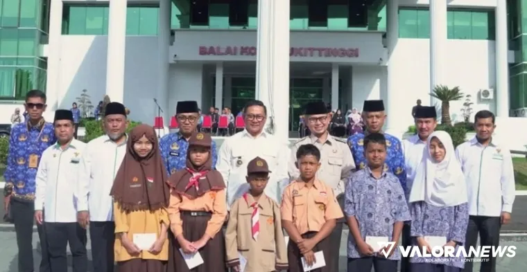 Wali Kota Bukittinggi, Ramlan Nurmatias, Ibnu Azis (Wawako), Edi Syahmian (Ketua Baznas) dan jajaran lainnya, foto bersama pelajar usai penyerahan bantuan pada program Bukittinggi Cerdas di halaman balai kota, Kamis. (hamriadi)
