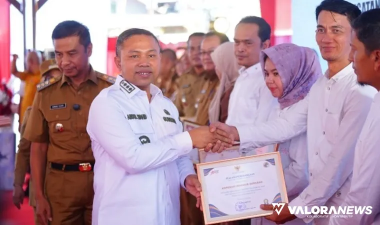 Gubernur Riau, Abdul Wahid menyerahkan penghargaan pada pengurus koperasi merah putih saat peluncuran secara nasional, Senin. (humas)