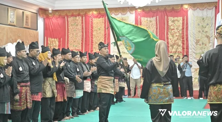 Ketua IPSI Sumbar, Vasko Ruseimy mengibarkan pataka usai pelantikan kepengurusan periode 2025-2029 di auditorium gubernuran, Kamis. (humas)