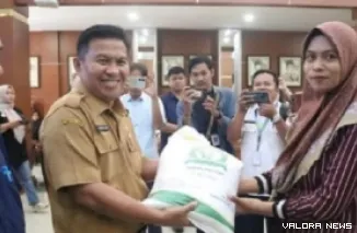 Sekda Bukittinggi, Rismal Hadi secara simbolis menyalurkan bantuan beras pada warga yang berhak di Aula Balai Kota Bukittinggi, Selasa. (huam)