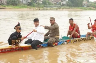 Gubernur Riau, Abdul Wahid menaiki jalur atau perahu panjang bersama si bocah viral 'Aura Farming,' Rayyan Arkan Dikha, usai mengujungi Tepian Narosa, Kamis. (humas)