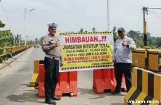 Personel Dishub Pemkab Rokan Hulu dan Polres Rohul, memasang pengumuman penutupan jalan total di perbaikan Jembatan Sungai Rokan, Sabtu. (humas)