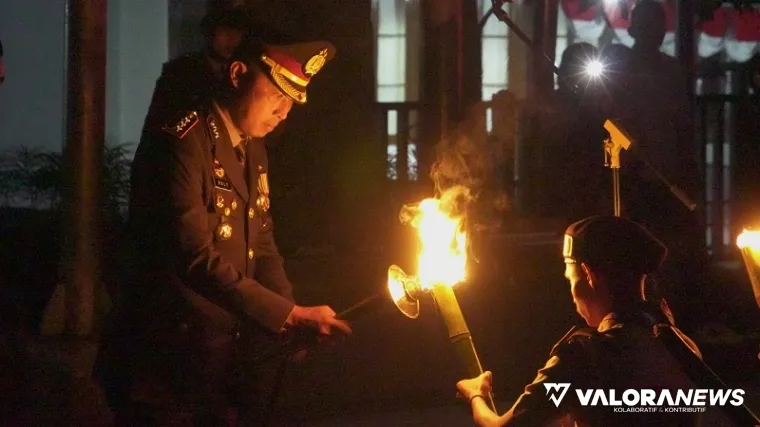Kapolresta Bukittinggi, Kombes Pol Ruly Indra Wijayanto nyalakan obor pada peserta pawai obor di Apel Taptu yang dipusatkan di depan Lapangan Wirabraja Bukittinggi, Sabtu malam. (hamriadi)