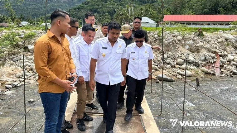 Wagub Sumbar, Vasko Ruseimy merasakan langsung goyangan jembatan gantung di Nagari Koto Rawang, Kecamatan IV Jurai, Kamis. (humas)