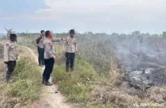 Personel Polri tengah memadamkan api Karhutla di kecamatan Simpang Kanan, Kabupaten Rokan Hilir. (humas)