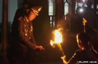 Kapolresta Bukittinggi, Kombes Pol Ruly Indra Wijayanto nyalakan obor pada peserta pawai obor di Apel Taptu yang dipusatkan di depan Lapangan Wirabraja Bukittinggi, Sabtu malam. (hamriadi)