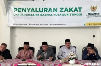 Staf Ahli Wali Kota Bukittinggi, Melfi Abra didampingi Yasril Rahamadian (Ketua Baznas Bukittinggi)  dan jajaran, pada penyaluran zakat pada 128 penerima di Kantor Baznas Kota Bukittinggi, Jumat. (humas)