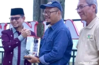 Wawako Bukittinggi, Ibnu Azis bertukar buku saat menyambut rombongan Guru Besar Perguruan Tinggi Negeri Badan Hukum (PTNBH) se-Indonesia di Taman Panorama, Sabtu. (humas)