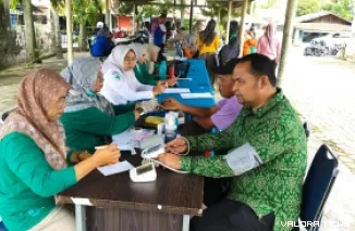 Anggota Komisi I DPRD Padang, Yusri Latif ikut memeriksakan kesehatan pada kegiatan CKG yang digelar Puskesmas Pauh pada peringatan Haornas 2025, Selasa. (veby rikiyanto)