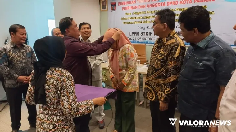 Pemasangan tanda peserta pada salah seorang anggota DPRD Padang yang mengikuti kegiatan Bimtek peningkatan pelayanan publik, di Jakarta, Rabu. (humas)