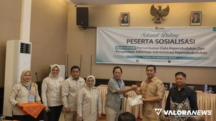 Kepala Disdukcapil Padang Teddy Antonius MenyerahkanTanda Peserta Secara Simbolis, Saat Membuka Kegiatan Sosialisasi Optimalisasi Pemanfaatan Data Penduduk, di Hotel Padang, Sabtu (18/10/2025)