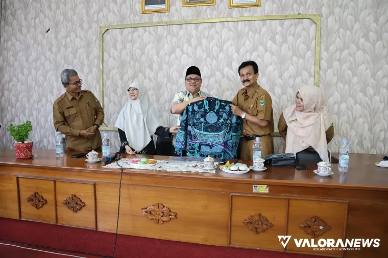 Ketua DPRD Sumbar, Muhidi secara simbolis menyerahkan baju batik untuk para guru dalam kunjungannya ke sejumlah sekolah di Padang, Selasa. (humas)