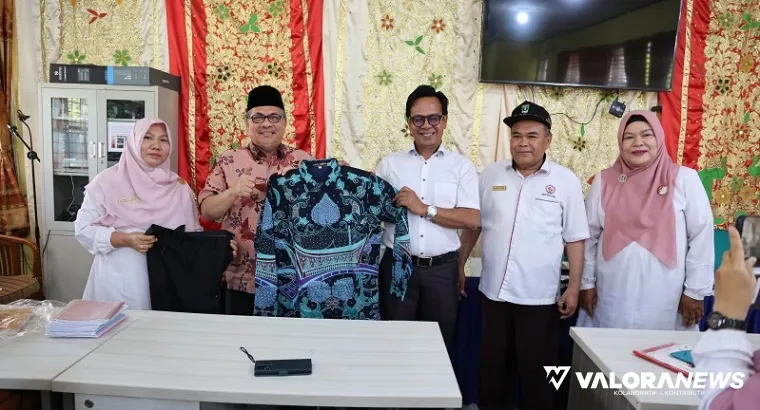 Ketua DPRD Sumbar, Muhidi serahkan secara simbolis bantuan baju batik bagi guru SMAN 16 Kuranji, Rabu. (humas)