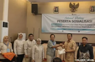 Kepala Disdukcapil Padang Teddy Antonius MenyerahkanTanda Peserta Secara Simbolis, Saat Membuka Kegiatan Sosialisasi Optimalisasi Pemanfaatan Data Penduduk, di Hotel Padang, Sabtu (18/10/2025)