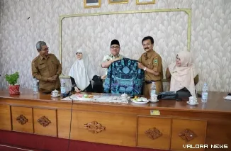 Ketua DPRD Sumbar, Muhidi secara simbolis menyerahkan baju batik untuk para guru dalam kunjungannya ke sejumlah sekolah di Padang, Selasa. (humas)