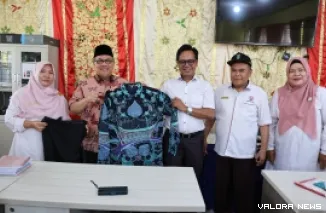 Ketua DPRD Sumbar, Muhidi serahkan secara simbolis bantuan baju batik bagi guru SMAN 16 Kuranji, Rabu. (humas)