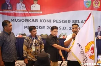 Ketua KONI Sumbar Hamdanus menyerahkan Bendera KONI kepada Ketua KONI Pessel terpilih M Adli, di Sago Painan, Sabtu (1/11/2025). FOTO: Yuka/KONI Pessel