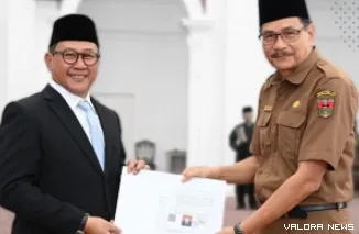 Wali Kota Bukittinggi, Ramlan Nurmatias menyerahkan sertifikat pensiun pada Melfi Abra yang telah bertugas selama 42 tahun sebagai ASN, Senin.  (hamriadi)