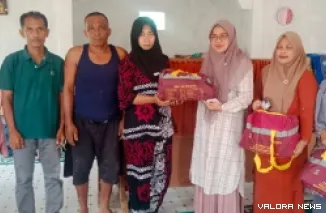 Ketua TP PKK Pasaman Barat, Sifrowati Yulianto serahkan bantuan bagi korban yang terseret air bah di Nagari Alahan Mati, Kecamatan Simpang Alahan Mati, Kabupaten Pasaman, Kamis. (humas)