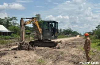 Camat Lalan, Jamian memantau alat berat yang merapikan ruas jalan TMMD yang menghubungkan desa di kecamatan Lalan menuju ibu kota kecamatan Lalan Desa Bandar Agung, Rabu. (toyipa)