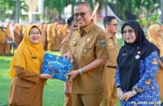 Sekdaprov Sumbar, Arry Yuswandi memberikan cenderamata pada perwakilan ASN Pemprov yang akan menunaikan ibadah haji tahun 1447 H/2026 M disela kegiatan apel pagi di halaman kantor gubernur, Senin. (humas)