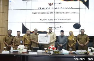 Wali Kota Padang Fadli Amran Menyerahkan Predikat Wilayah Bebas Korupsi dari Kemenpan RB Kepada Kepala Dinas Tenaga Kerja Ferry Erviyan Rinaldi Pada Monthly Meeting, Senin (6/4/2206)