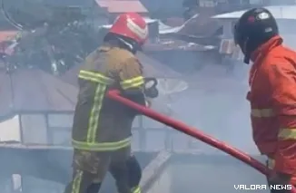 Dua orang petugas pemadam, tengah melakukan pendinginan atas kejadian kebakaran yang menimpa rumah semi permanen di Parak Kopi, Jl Setia Budi, Kelurahan Kayu Kubu, Kecamatan Guguk Panjang, Kamis. (hamriadi)