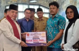 Bupati Agam, Benni Warlis menyerahkan secara simbolis bantuan Rumah Tidak Layak Huni (RTLH) Kabupaten Agam Tahun 2026 pada perwakilan warga Nagari Padang Tarok di Masjid Al-Huda, Nagari Padang Tarok, Kecamatan Baso, Selasa. (anizur)