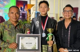 Kepala SMA Negeri 2 Lubuk Basung, Zulkifli bersama siswanya, Ravi Ananda Fersa usai menerima piala juara II Lomba Video dan Lagu Pasan Buruang Antar SMA/SMK se-Sumatera Barat Tahun 2026, Jumat. (anizur)